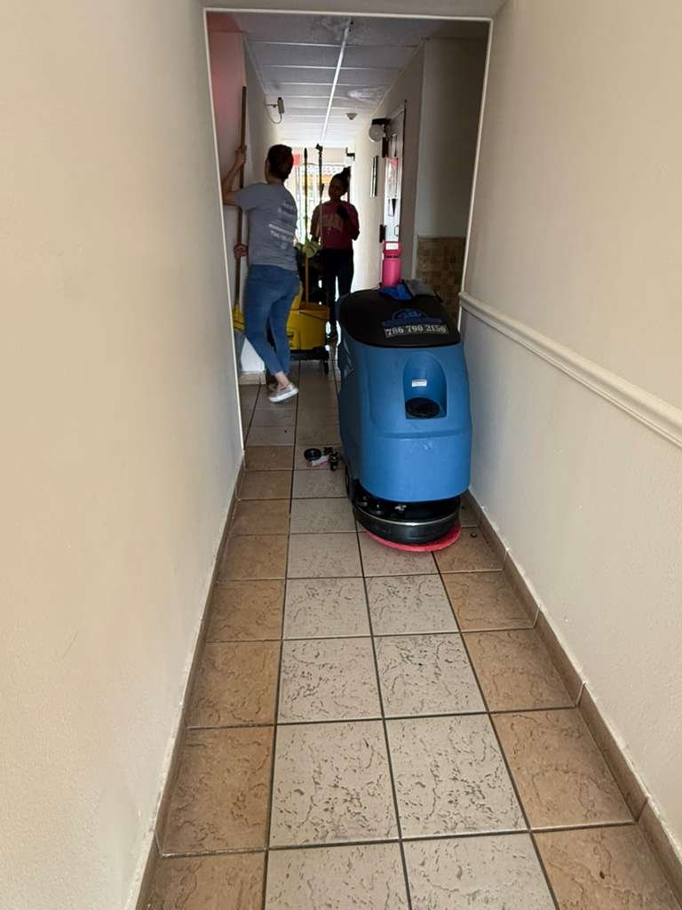 Floor scrubber machine cleaning a commercial hallway