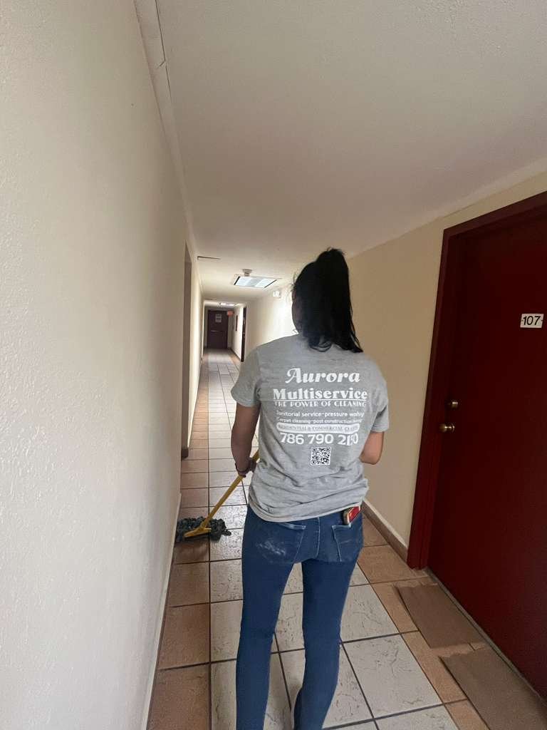 Aurora Multiservice crew member mopping a condominium hallway